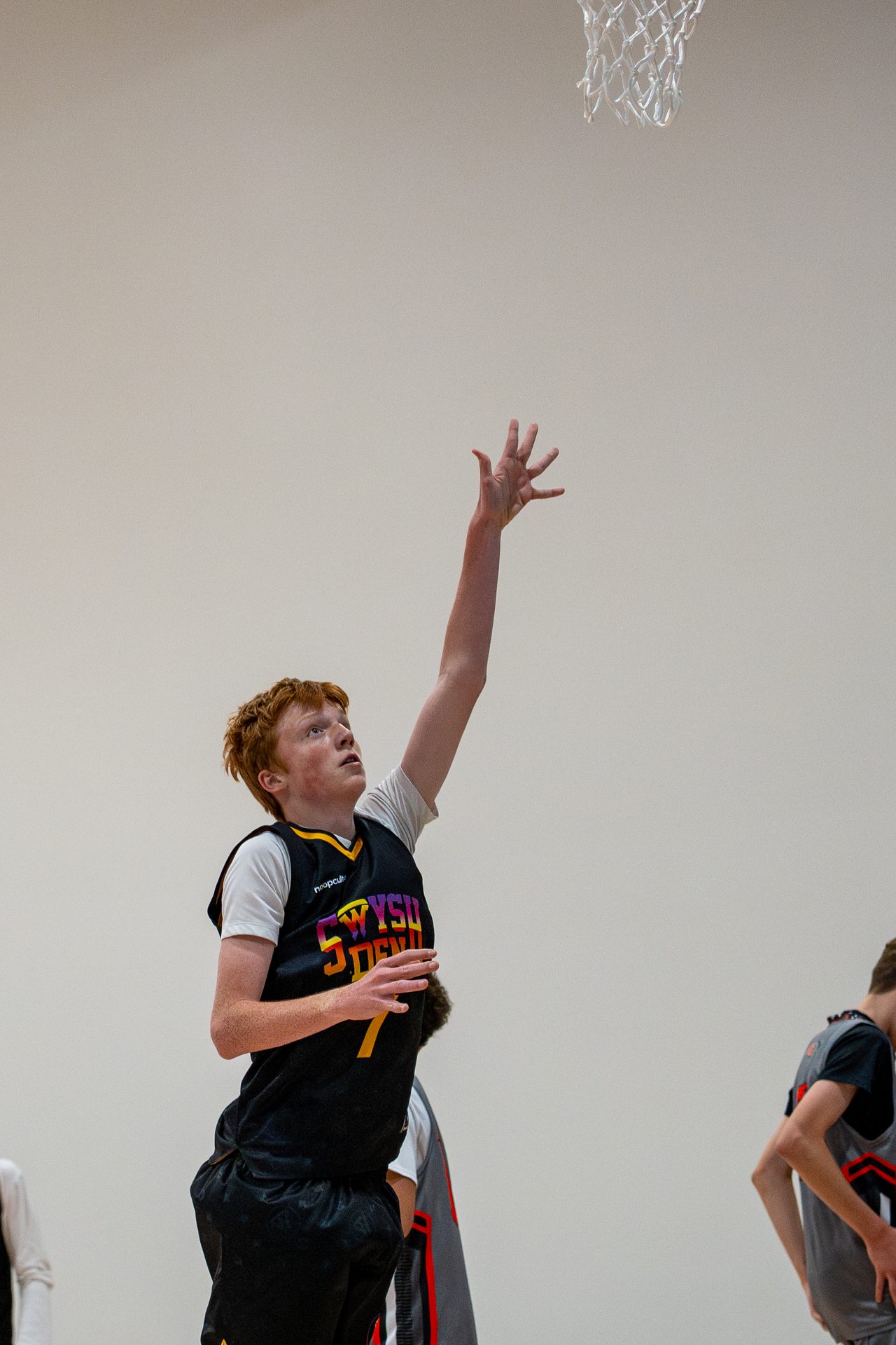 A Swysh Den Club Team player finishing at the rim
