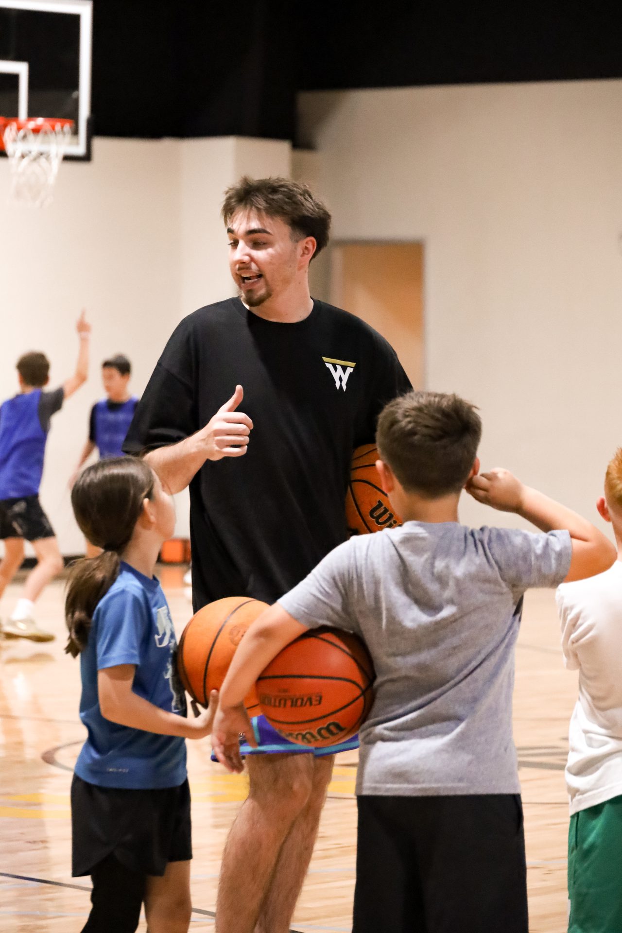 Coach leading a small group of young players on the indoor court at Swysh Den in Scottsdale