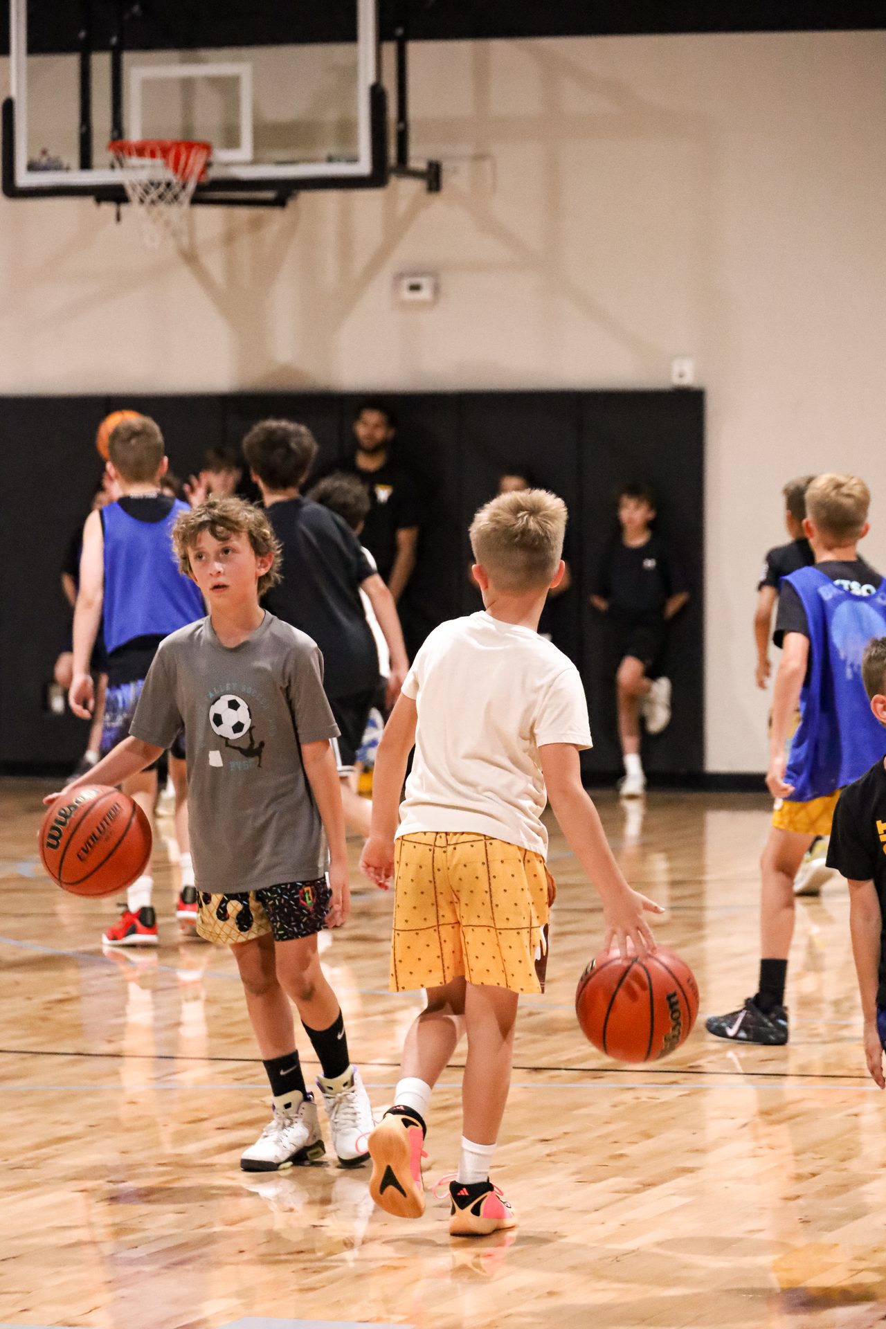 Campers dribbling basketballs together during a group warmup drill at Swysh Den summer camp