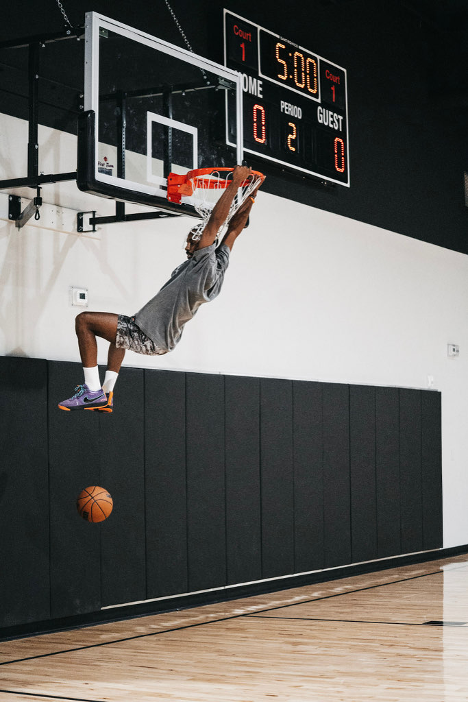 A Swysh Flight School player hanging on the rim after a dunk